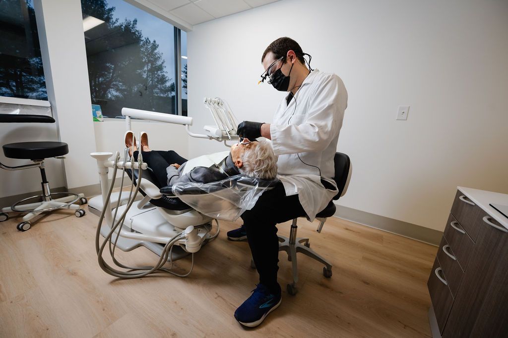 Dr. Ryan Eckley, wearing a mask and loupes, treats a patient in the dental chair at Eckley Family and Cosmetic.